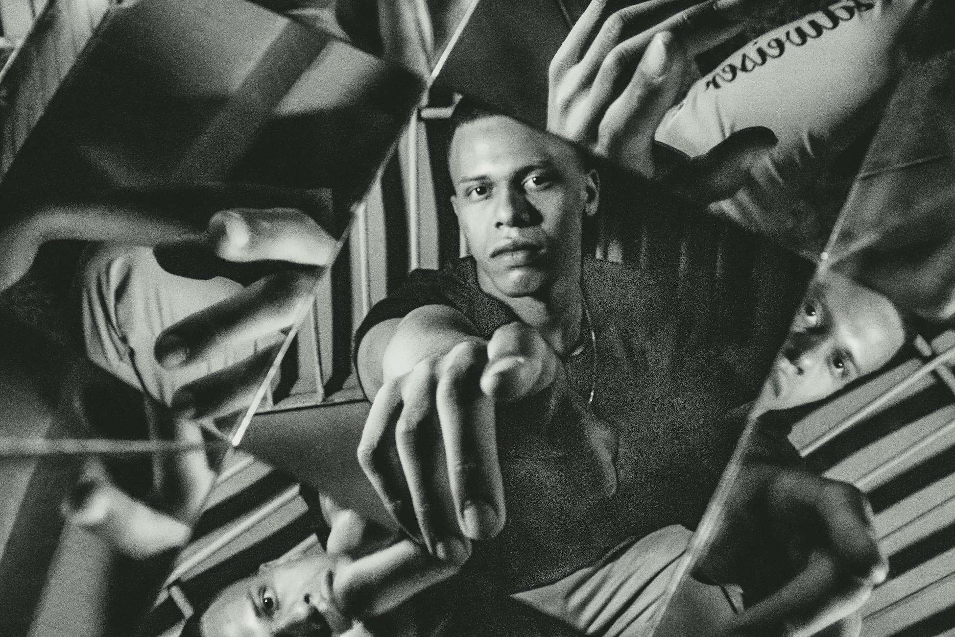 Creative black and white portrait capturing a man with multiple reflections and intriguing patterns.