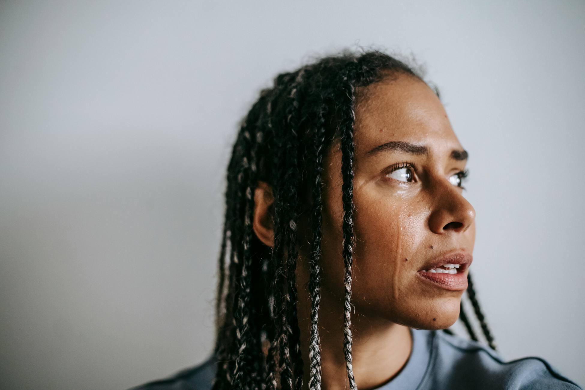 Close-up of a woman looking pensive, highlighting emotion and introspection.