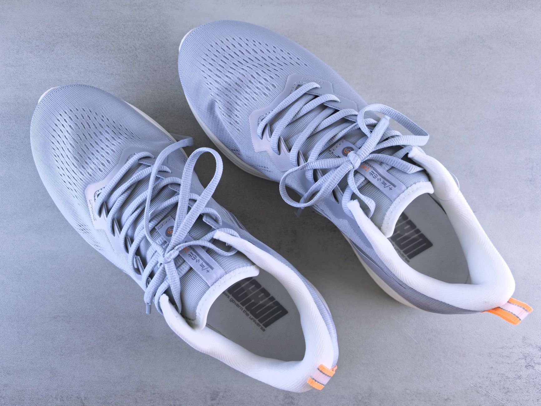 Stylish grey sneakers captured in a top-down perspective against a neutral grey background.