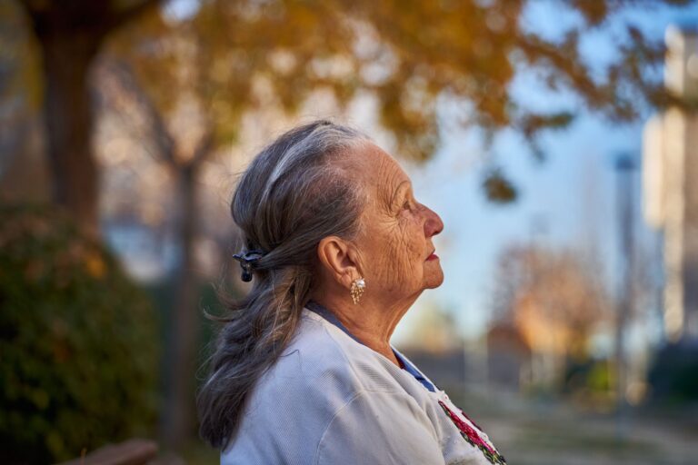 Side profile portrait of a senior woman in a sunny autumn park, San Sebastián de los Reyes.