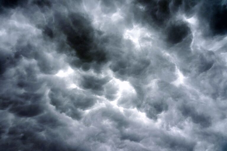 Majestic storm clouds fill the sky, creating a dramatic, moody atmosphere.